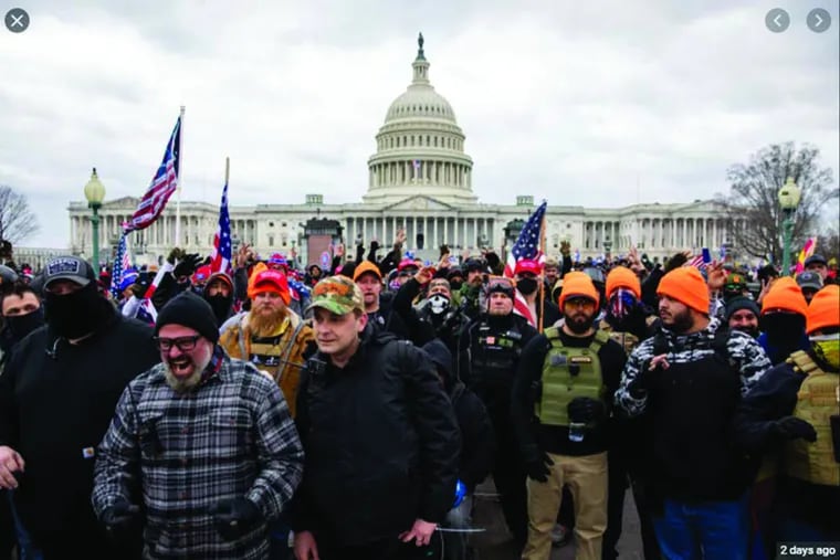 Philly Proud Boys President Zach Rehl (center, in camouflage hat) and Joe Biggs, a leader of the group from Florida (left, in gray plaid shirt) stand at the forefront of a crowd of members of the organization that marched on the U.S. Capitol in Washington on Jan. 6, 2021.
