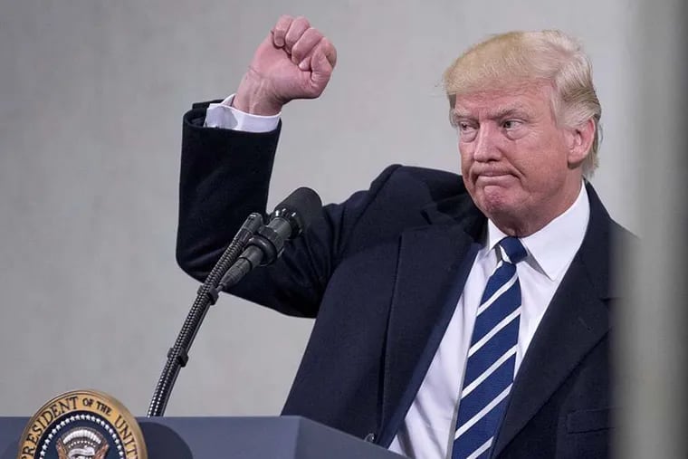 President Donald Trump holds up a fist after speaking at the Central Intelligence Agency in Langley, Va., Saturday, Jan. 21, 2017.
