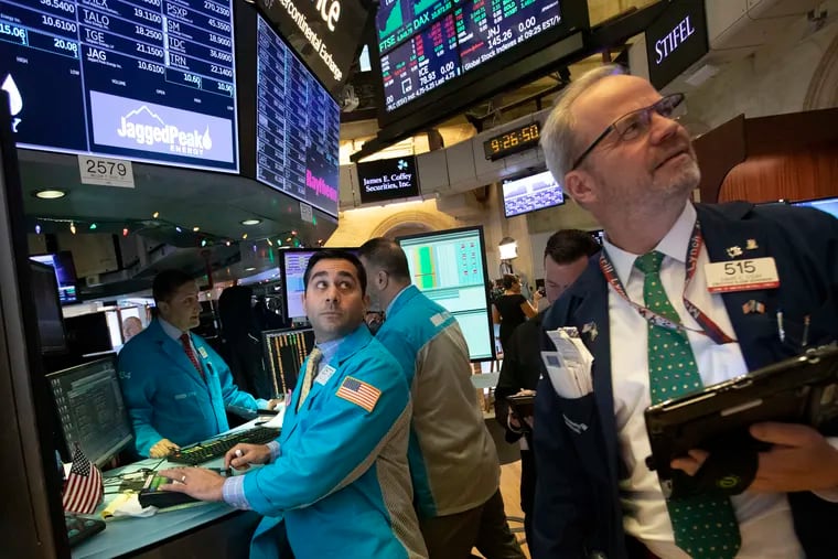 William Geier, Jr., left, and David O'Day work at the New York Stock Exchange, Tuesday, Dec. 11, 2018, in New York. Stock markets around the world spiked higher Tuesday after Wall Street rebounded amid hopes the U.S. and China are back negotiating over their trade dispute. (AP Photo/Mark Lennihan)