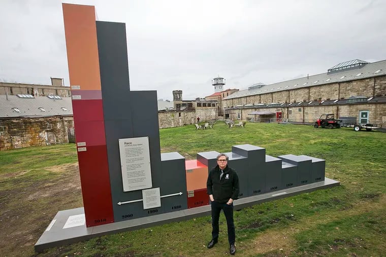 Sean Kelley of Eastern State Penitentiary stands before "The Big Graph," a 16-foot-high bar chart tracking prison population growth.