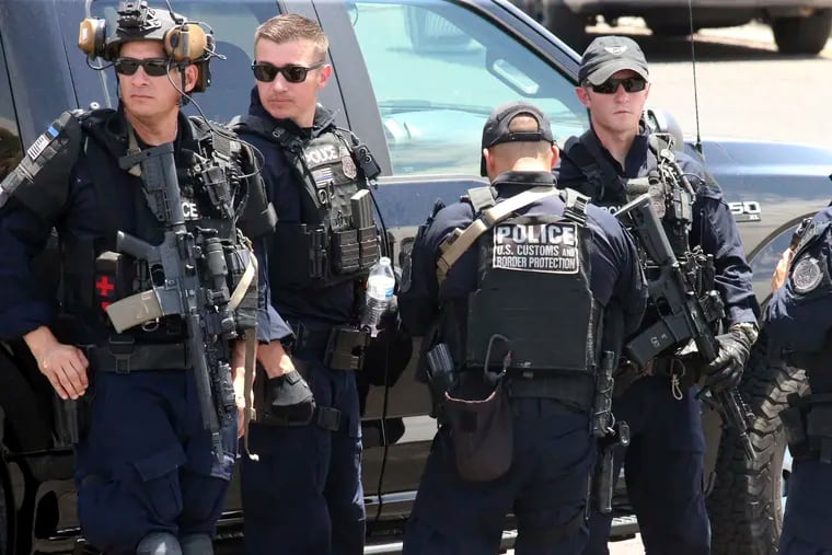 U.S. Customs and Border Protection officers gather near the scene of a shooting at a shopping mall in El Paso, Texas, on Saturday, Aug. 3, 2019.   Multiple people were killed and one person was in custody after a shooter went on a rampage at a shopping mall, police in the Texas border town of El Paso said. (AP Photo/Rudy Gutierrez)