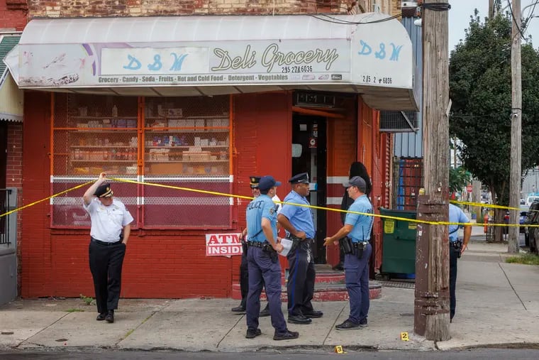 Philadelphia Police stand outside a corner Grocery Deli at 23rd and Oakford, where a shooting took place on Thursday morning.