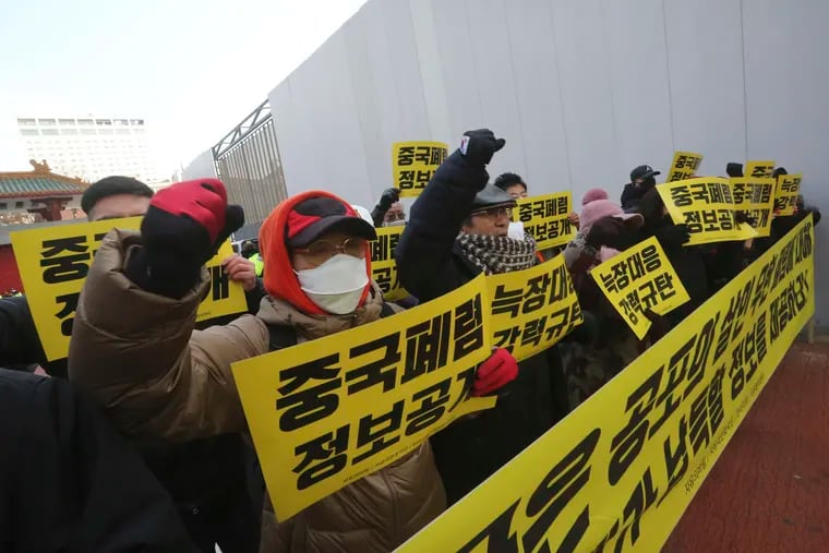 Protesters hold signs calling for a ban on Chinese people entering South Korea near the Chinese embassy in Seoul, South Korea, on Feb. 4, 2020. The signs read: "Release the information for Wuhan Coronavirus."