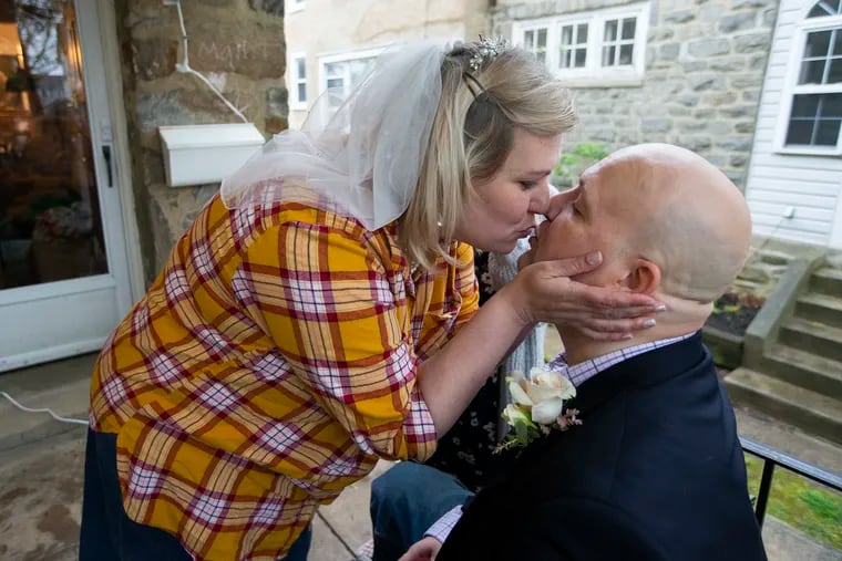 Joy Karsner, 39, kisses her fiance, Brian Barton, 44, before going to change clothes for the ceremony. The Springfield couple eloped on their front lawn on April 24, 2020 . The officiant is Zooming in from Rochester, 300 guests are attending Facebook, and their neighbors plan to dress up and stand in their driveways.  Joy's three daughters will participate in the ceremony.
