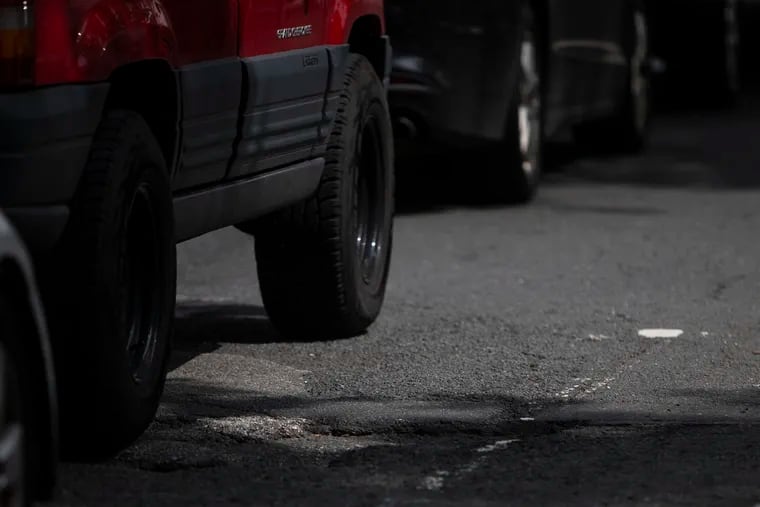 Cards drive over potholes on Ogontz Ave. between Stenton and Medary Ave. on Tuesday, June 18, 2019. Ogontz Ave. has the fifth most potholes citywide, according to city data.