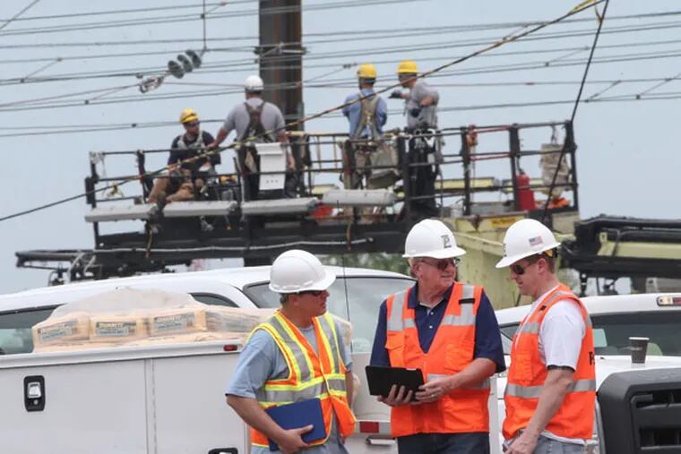 Last week's derailment has meant ramped up operations at family-owned PennFab, the Bucks County company that landed the emergency contract to supply steel for repairs to the destroyed rails. Company owner Mike Mabin Sr., center Mike Mabin Jr., right and Steven Krotzer on left as workers repair the "Catenary" wires near the scene of the fatal Amtrak derailment in Philadelphia, May 17, 2015  (Steven M. Falk / Staff Photographer)