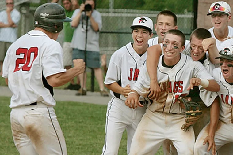 Jackson H.S. players celebrate as teammate Alex Herceg crosses homeplate after hitting a solo homerun in the 6th inning. (Elizabeth Robertson / Staff Photographer)