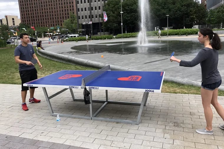 Nassim Motya (left) and Angie Sheehan play Ping Pong on tables free to use in Love Park.