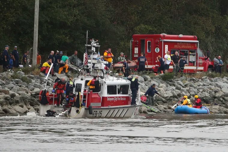 Emergency personnel, including divers, work on the Chesapeake & Delaware Canal where a vehicle plunged into the water from South Canal Road, west of St. Georges, Del., Sunday, Oct. 6, 2019. (William Bretzger/The News Journal via AP)