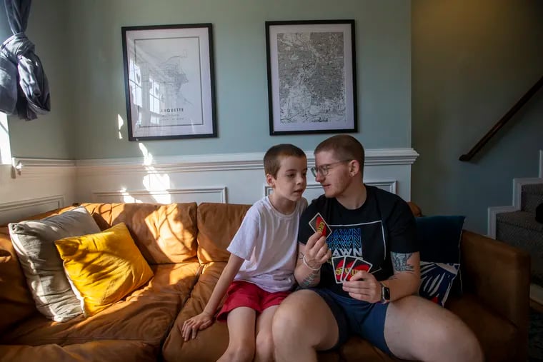 Krys Malcolm Belc asks for help about UNO rules from son Sean Belc, 8, as he plays against his two other children in their home in Kensington.  Belc is a trans man who's written: "The Natural Mother of the Child: A Memoir of Nonbinary Parenthood."