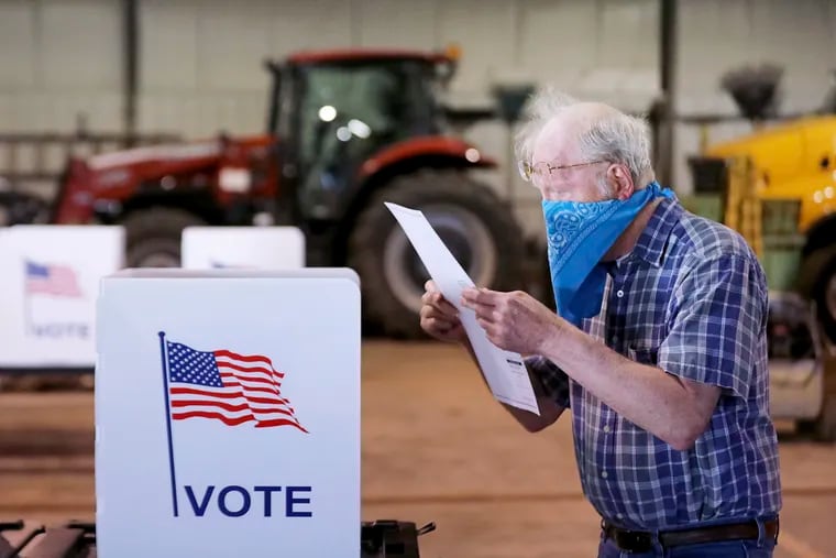 A voter in Wisconsin reviews his ballot while voting Tuesday, April 7, 2020, during the coronavirus pandemic.