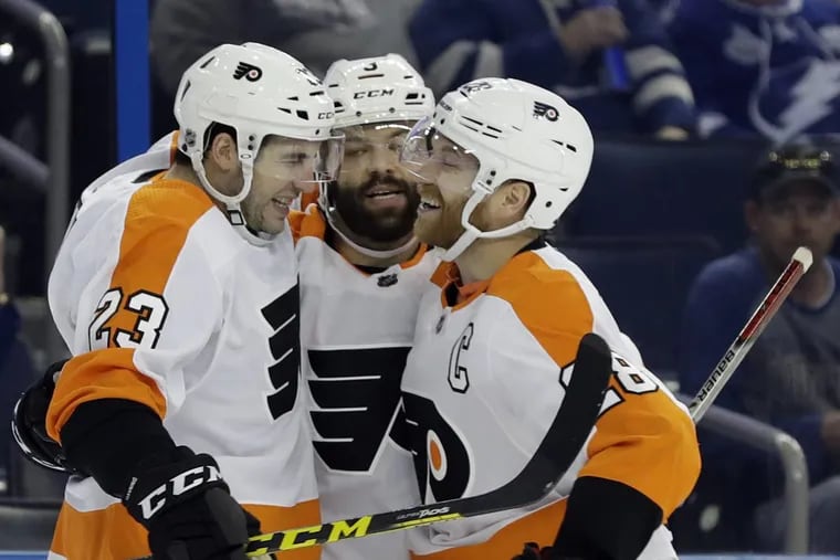 Defenseman Brandon Manning (left) celebrates his goal against Tampa Bay with Radko Gudas (center) and Claude Giroux (right) during the third period of the Flyers’ 5-3 win Friday.
