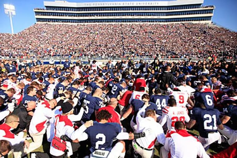 Penn State and Nebraska players pray together before the start of Saturday's game. (David Swanson/Staff Photographer)