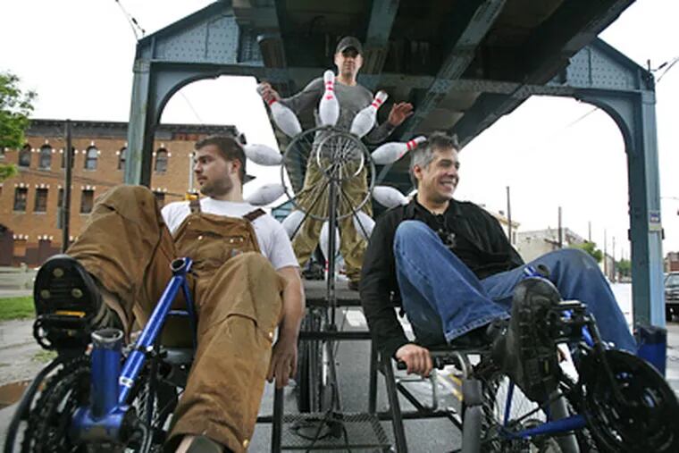 With pins and pedals, cruising under the El on Front Street during a test run for their entry in the Kensington Kinetic Sculpture Derby are (from left) John Spetrino, Tom Carr, and Erik Silverson. (Eric Mencher / Staff Photographer)