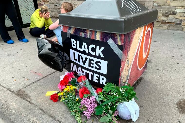 People gather around a makeshift memorial Tuesday in Minneapolis.