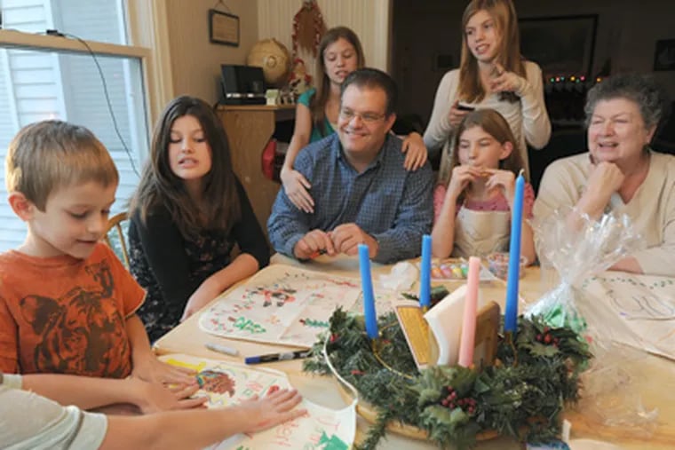 Gathered at the table for Christmas projects are Rich Vosler and his
mother-in-law, Maryann Marrone, along with children (from left) Emily, James, Jessica, Sarah, Alyssa, and Anna. Mommy’s Light had dropped off cookie dough and aprons to be decorated. (April Saul / Staff Photographer)