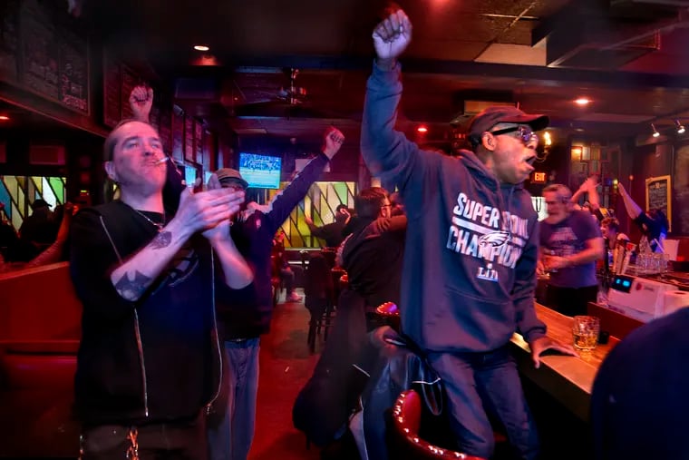 At McGlinchey's Bar, Butch Dwight of South Philadelphia (right) and server Jon Rhodes celebrate after the Eagles defeat the Chicago Bears.