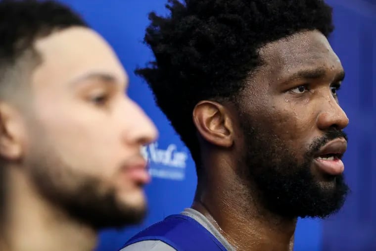 Joel Embiid (right) talking with reporters as Ben Simmons stands nearby during Sixers practice in Camden on Jan. 2.