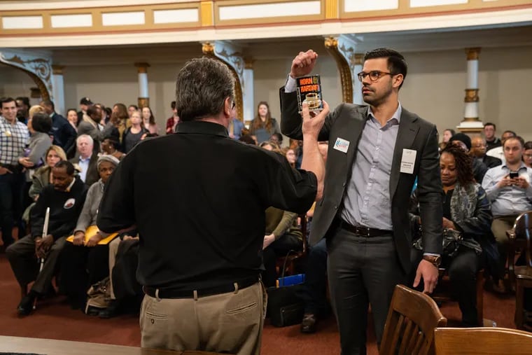 Adrian Rivera-Reyes draws the number one ballot position in the Democratic primary for Council at-large in room 676 of City Hall, in Philadelphia, Wednesday March 20, 2019. Holding the can is Kevin Kelly, acting supervisor of elections.
