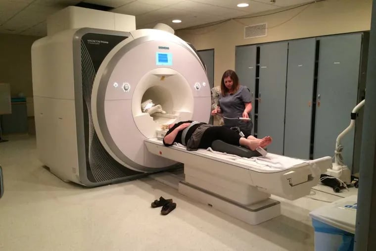 MRI technologist Tracy Lagamba prepares Denise Gross for her neurofeedback session in the MRI.