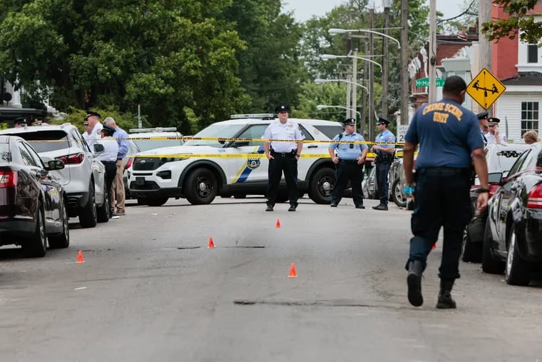 Police respond to a triple homicide on the 700 block of East Locust Avenue in Philadelphia on Thursday. Two men and a 12-year-old boy were killed. .
