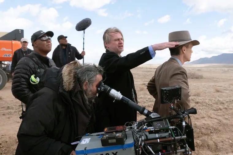 A photo released by Universal Pictures shows director Christopher Nolan (center) and Cillian Murphy (right) on the set of "Oppenheimer."
