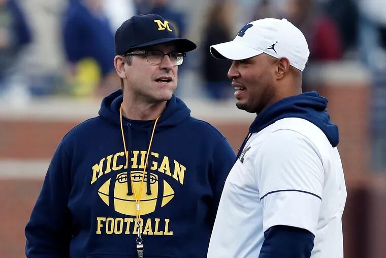 Michigan head coach Jim Harbaugh, left, and offensive coordinator Josh Gattis talking during the team's annual spring football game in April.
