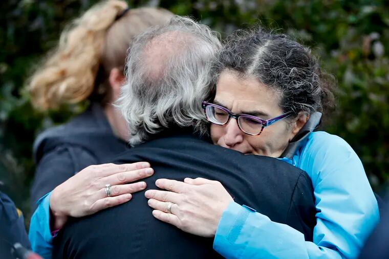 People embrace along the street in the Squirrel Hill neighborhood of Pittsburgh where a shooter opened fire during services at the Tree of Life Synagogue on Saturday, Oct. 27, 2018.