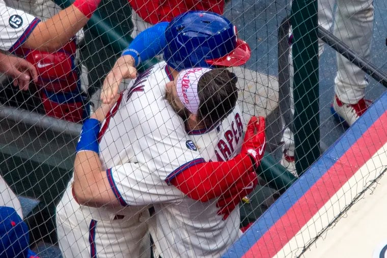 Bryce Harper (right) hugs Mickey Moniak after the rookie center fielder hit his first major-league home run Wednesday.
