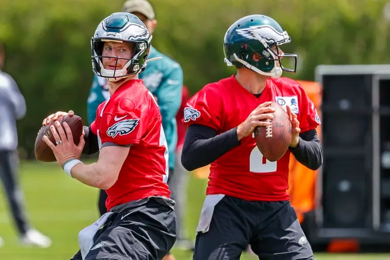 Eagles quarterbacks Carson Wentz (left) and Cody Kessler take part in a passing drill on the first day of OTAs.