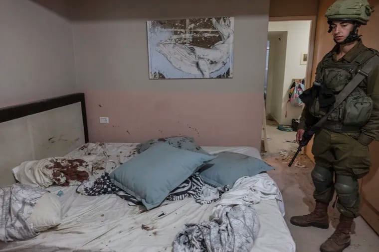 An Israeli soldier looks at a bed stained with blood in a home at Kibbutz Be'eri near the Gaza border where people were killed on Oct. 7.