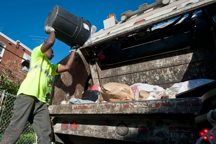 Philadelphia trash collector Mamadou Sacko empties a trash can on a route in the Northeast in 2014.