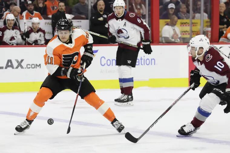 Flyers right winger Travis Konecny skates with the bouncing puck against Colorado's Sven Andrighetto during the Avs' 4-1 win Monday at the Wells Fargo Center.