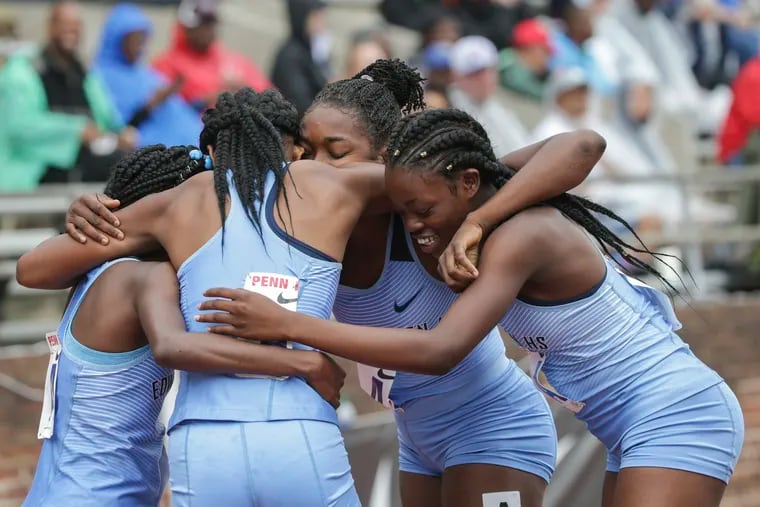 Jessica McLean, Kayan Green, Nadine Rose, and Rushana Dwyer of the Edwin Allen Comprehensive High School in Clarendon, Jamaica, embrace after finishing first in the high school girls' 4x800 Championship of America relay.