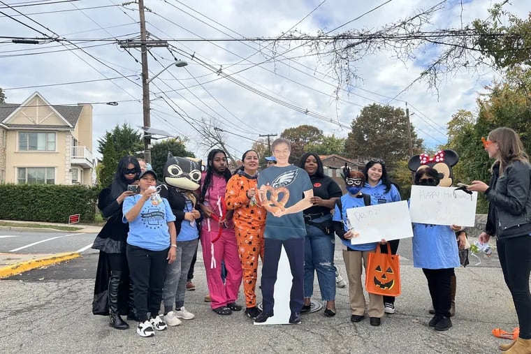 Members of Make the Road Action New Jersey and Pennsylvania and the Working Families party gather around a cutout of Mehmet Oz. On Halloween, the group went 'Trick or Treating' in Cliffside Park, N.J., where Oz lived for more than 20 years.