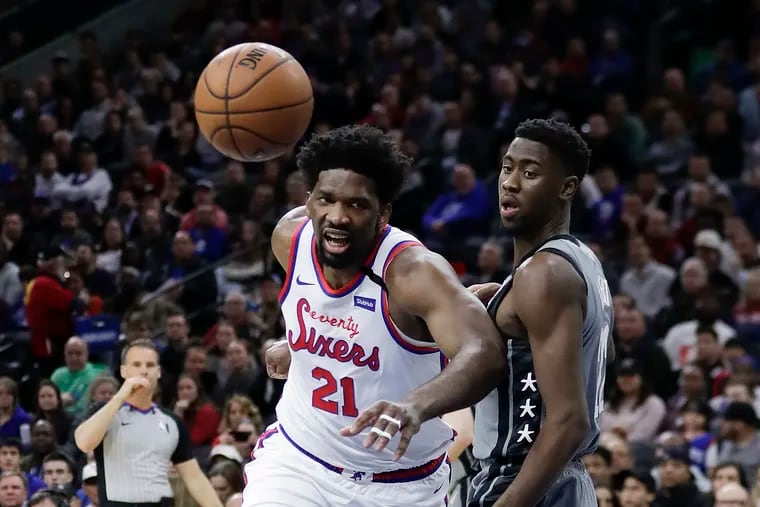 Sixers center Joel Embiid goes after the basketball against Brooklyn Nets guard Caris LeVert on Thursday, February 20, 2020 in Philadelphia.