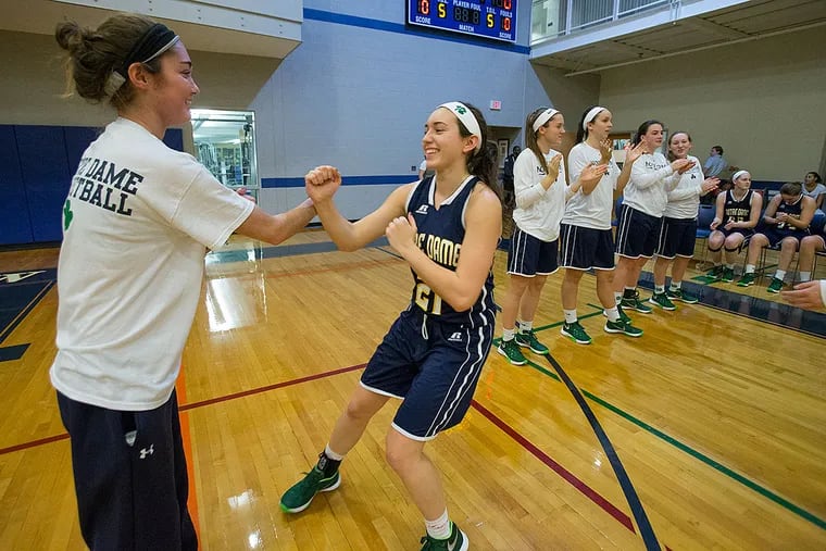Notre Dame senior Leanne Purcell (left) greets teammate Alex Kane as the Notre Dame starting lineup is introduced before their game at the Baldwin School.