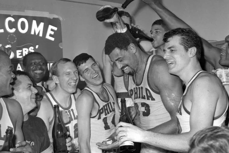 Wilt Chamberlain gets champagne poured on him in the 76ers dressing room after they defeated the Boston Celtics 140-116 to win the Eastern Division final.