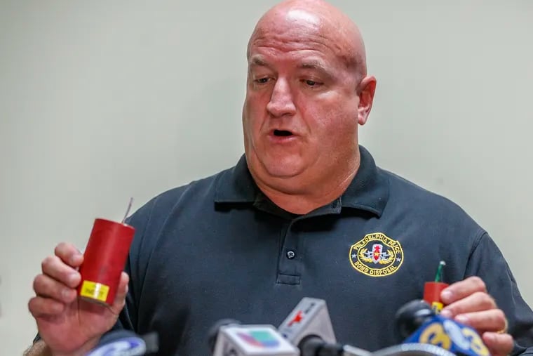 On Monday, July 1, 2019, Detective Tim Brooks of the Philadelphia Police bomb squad holds up two illegal explosive devices similar to one that exploded and critically injured a 9-year-old girl in her home in Kensington the previous night.