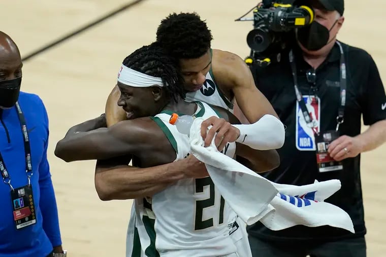 Milwaukee Bucks forward Giannis Antetokounmpo, top, celebrated with guard Jrue Holiday after the Bucks defeated the Phoenix Suns in Game 5 of the NBA Finals.