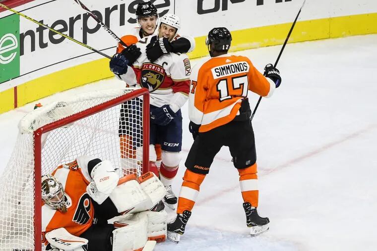 Shayne Gostisbehere and Wayne Simmonds have words with the Panthers’ Derek MacKenzie for pushing goalie Michal Neuvirth down while Claude Giroux was busy scoring at the other end of the rink Tuesday.