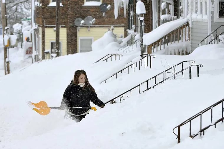 Rochelle Carlotti, 28, shovels steps near her home after a record snowfall on Tuesday, Dec. 26, 2017, in Erie, Pa. The National Weather Service office in Cleveland says Monday&#039;s storm brought 34 inches of snow, an all-time daily snowfall record for Erie.