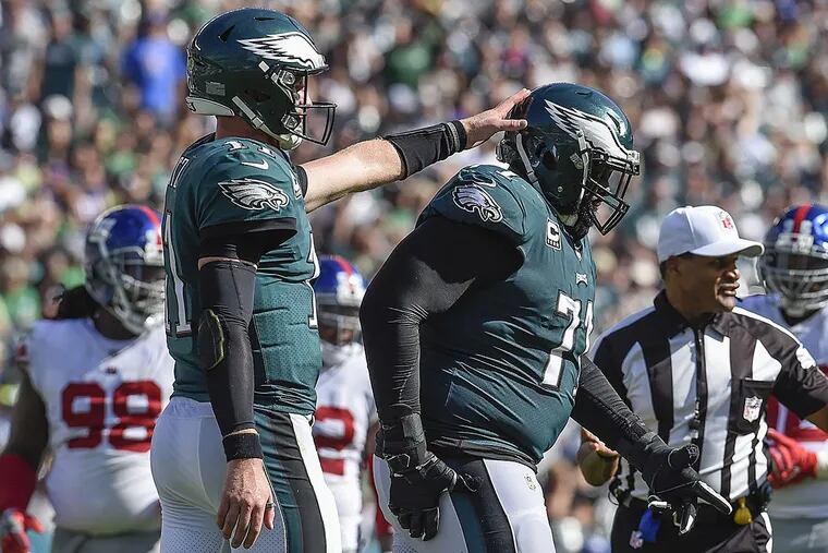 Eagles quarterback Carson Wentz gives tackle Jason Peters a pat on the helmet during a game against the Giants.