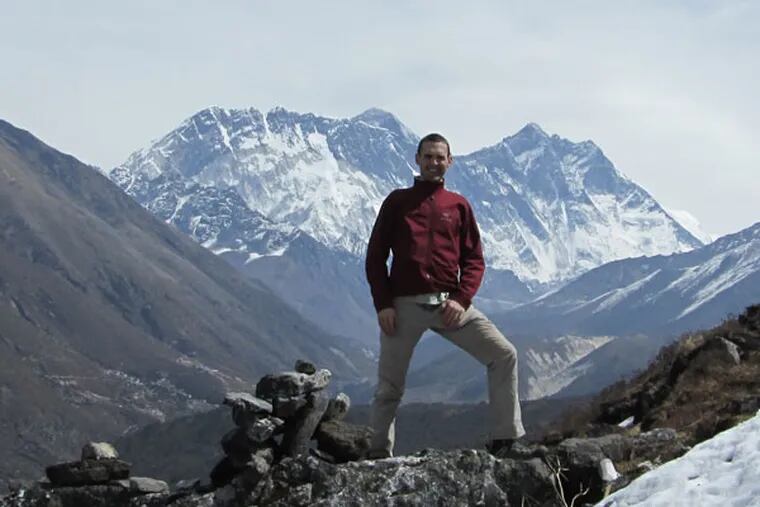 Andrew Towne stood on a ridge above the Tengboche monastery.  Everest is poking out from behind Nuptse in the background (Photo courtesy of Andrew Towne).
