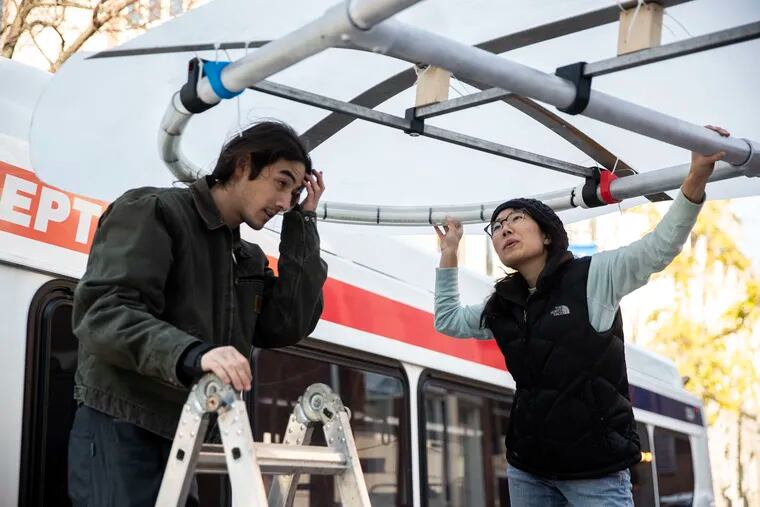 Colin Lew (left) and Grace Choi work on the prototype of their bike corral, Harbor, before the Rack 'Em Up Philly finals Wednesday. They and other members of the group were classmates in Thomas Jefferson University's master's in industrial design program.