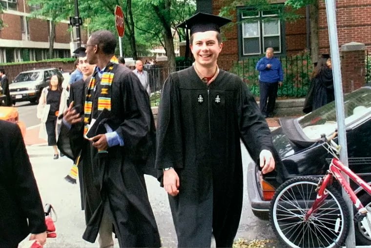 In this image provided by the Pete Buttigieg presidential campaign, Pete Buttigieg walks with his friend Uzo, left, to meet his parents before going ot his house graduation at Leverett House at his Harvard graduation on June 10, 2004 in Cambridge, Mass. (Pete Buttigieg Presidential Campaign via AP)