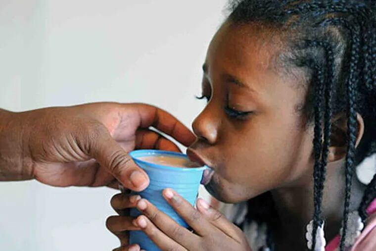 Micah Moses, 4, gets milk from her mother, Shontaya.  (Sharon Gekoski-Kimmel / Staff Photographer)