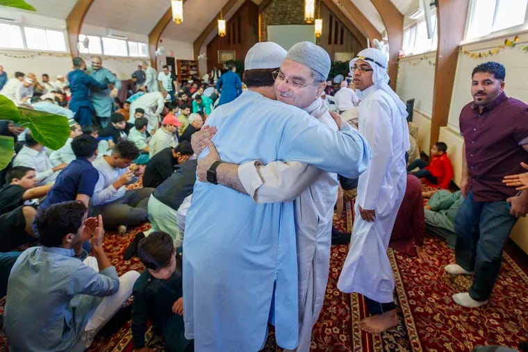 To celebrate the holiday of Eid al-Fitr, on June 4, 2019, Abid Siddiq, center, hugs one of his his fellow worshipers at the end of morning prayer at the Muslim Youth Center of Philadelphia that signals the end of Ramadan.