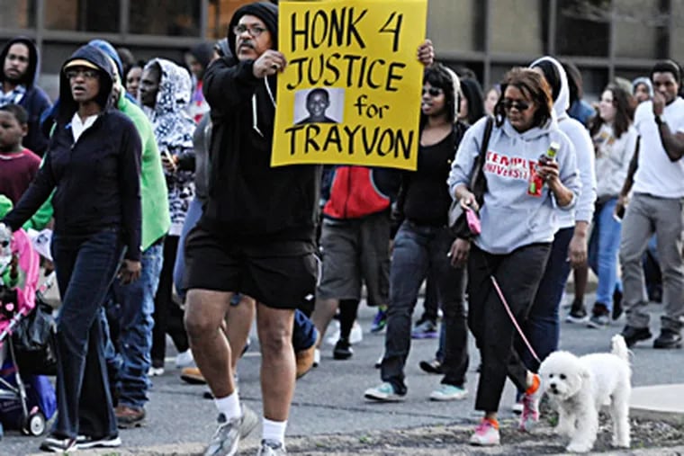 A man prompts drivers to honk their car horns as protesters march along JFK Boulevard to a rally for slain Florida teen Trayvon Martin. RON TARVER / Staff Photographer