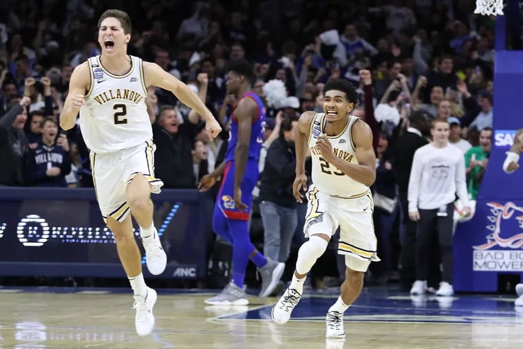 Collin Gillespie, left, and Jermaine Samuels, right,  of Villanova celebrate after their 56-55 victory over top-ranked Kansas  at the Wells Fargo Center on Dec. 21, 2019. Udoka Azubuike of Kansas walks off the court in the background.